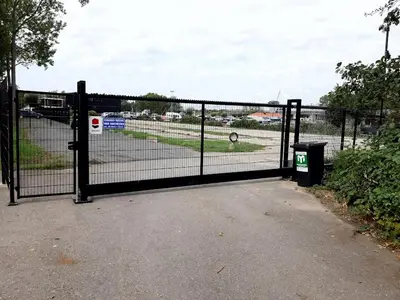 a black fence with a trash can in front of it at Motorjacht Flint in Amsterdam