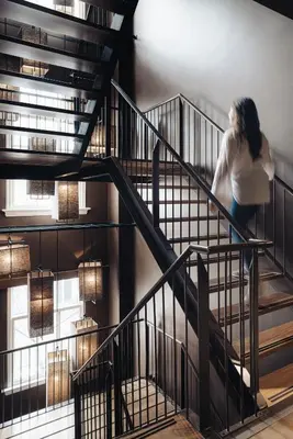 a woman walking down the stairs in a building at Sir Albert Hotel, part of Sircle Collection in Amsterdam