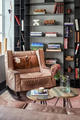a leather couch in a living room with a table at Sir Albert Hotel, part of Sircle Collection in Amsterdam
