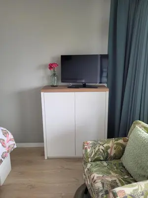 a living room with a tv and a couch at Zeesterflat 117 in Egmond aan Zee