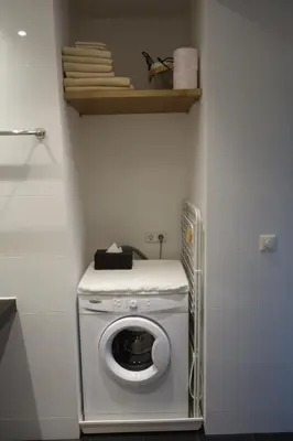 a washer and dryer in a corner of a room at Zeesterflat 117 in Egmond aan Zee