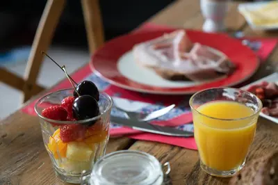 a table with a plate of fruit and a glass of orange juice at B&B Posthoorn in Hoorn