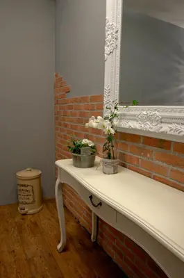 a white table with a mirror and flowers on it at B&B Posthoorn in Hoorn