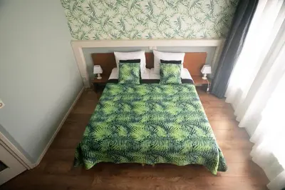 a bedroom with a bed with a green blanket and pillows at B&B Posthoorn in Hoorn