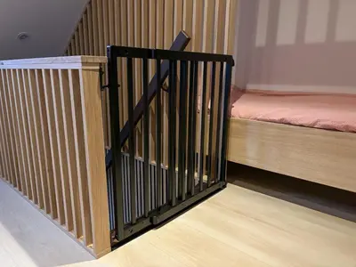 a stair railing in a room with a bed at Casa Bon Bini in Egmond aan Zee
