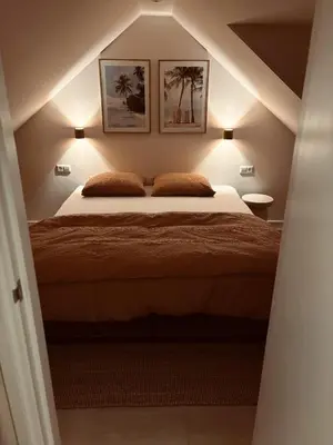 a bedroom with a bed with two pictures on the wall at Casa Bon Bini in Egmond aan Zee