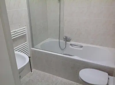 a bathroom with a white tub and a toilet at Apartment at the Beach in Noordwijk aan Zee