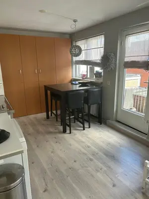 a kitchen with a table and chairs in a room at Apartment at the Beach in Noordwijk aan Zee
