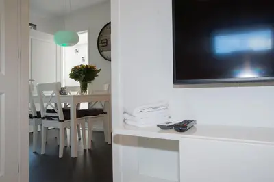 a room with a table and a television on a wall at 4 Seasons Zandvoort in Zandvoort