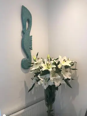a vase filled with white flowers in a wall at 4 Seasons Zandvoort in Zandvoort