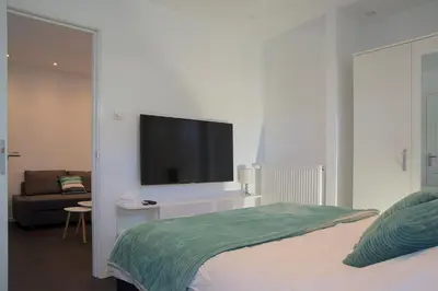 a bedroom with a flat screen tv on a white wall at 4 Seasons Zandvoort in Zandvoort