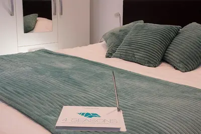 a green blanket on a bed with a sign on it at 4 Seasons Zandvoort in Zandvoort