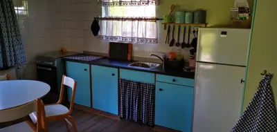 a kitchen with blue cabinets and a white refrigerator at Bed & Breakfast Prins Hendrik (Zuidschermer) in Zuidschermer