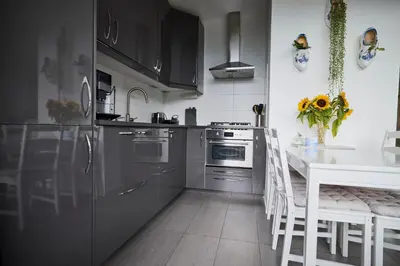 a kitchen with stainless steel appliances and a white table at Treehouse Inn in Duivendrecht
