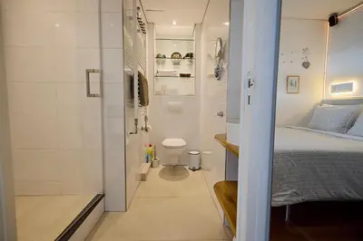 a small bathroom with a bed and a shower at Treehouse Inn in Duivendrecht