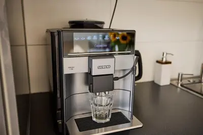 a coffee maker with a glass in it on a counter at Treehouse Inn in Duivendrecht