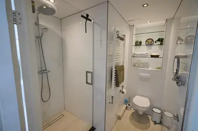 a white bathroom with a shower and a toilet at Treehouse Inn in Duivendrecht