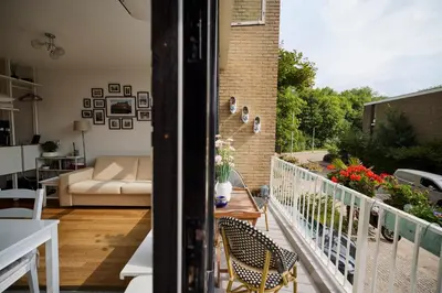 a balcony with a couch and a table and chairs at Treehouse Inn in Duivendrecht