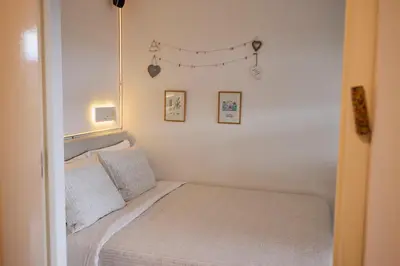 a small bedroom with a bed and some pictures on the wall at Treehouse Inn in Duivendrecht