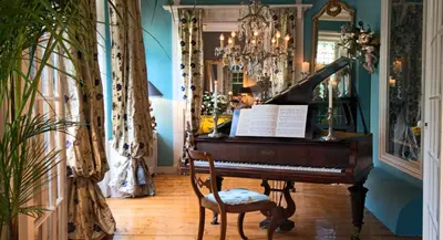 a piano in a room with a chair and a mirror at Breitner House in Amsterdam