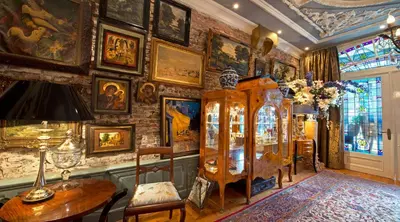 a room with a table and a wall filled with paintings at Breitner House in Amsterdam