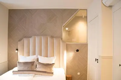 a bedroom with a white bed with a wooden headboard at House of Amstel in Amsterdam