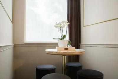 a table with two stools in a room with a window at House of Amstel in Amsterdam