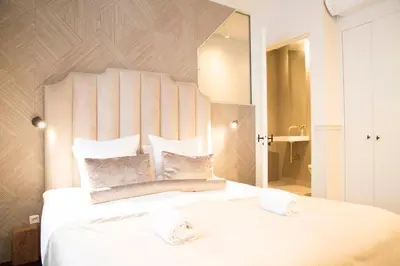 a bedroom with a large white bed with a large mirror at House of Amstel in Amsterdam