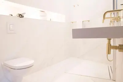 a white bathroom with a toilet and a sink at House of Amstel in Amsterdam