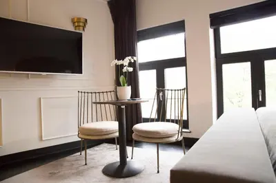 a bedroom with two chairs and a table with a tv at House of Amstel in Amsterdam