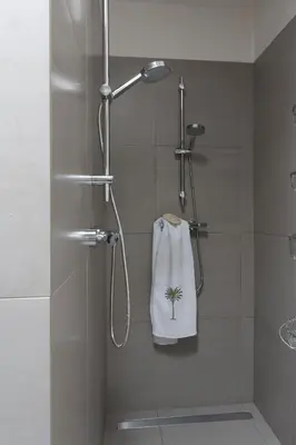 a shower with a towel with a palm tree on it at Stylish * Sunny * Cosy House in Heemstede