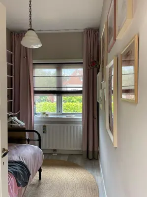 a bedroom with a window and a bed and a rug at Stylish * Sunny * Cosy House in Heemstede