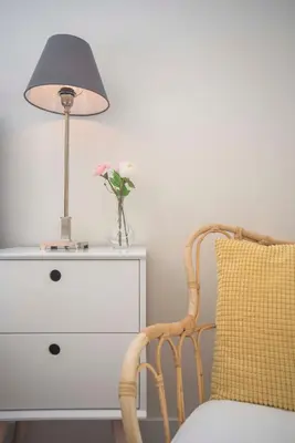 a lamp and a chair next to a dresser at The Bond Studio FREE PARKING in Zandvoort