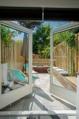 a patio with a sliding glass door and a chair at The Bond Studio FREE PARKING in Zandvoort