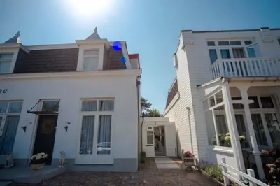 a white house next to a white building at The Bond Studio FREE PARKING in Zandvoort