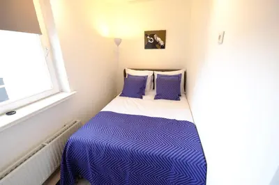 a small bedroom with a bed with blue and white sheets at Citycenter Residence in Amsterdam