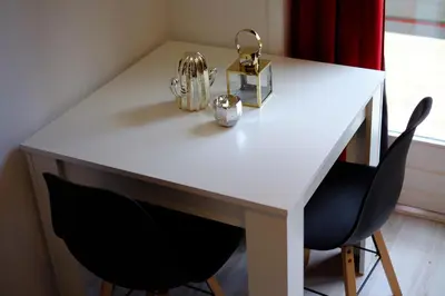 a white desk with two black chairs and a white table at Citycenter Residence in Amsterdam