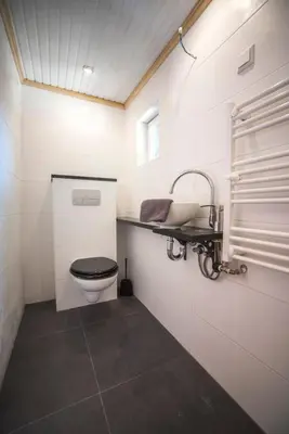 a white bathroom with a toilet and a sink at Ocho in Zandvoort