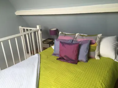 a bed with colorful pillows on top of it at Blaine's: A B&B and private dining.... in Amsterdam