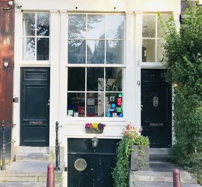 a house with two black doors and a window at Tulip of Amsterdam in Amsterdam