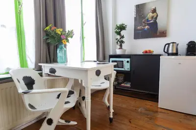 a white desk with two chairs and a vase with flowers at Tulip of Amsterdam in Amsterdam