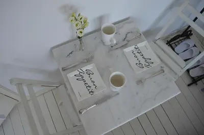 a white table with two cups and flowers on it at Bed & Breakfast Jo Amsterdam in Amsterdam