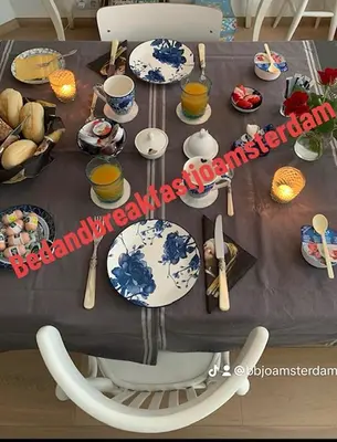 a table with blue and white plates and utensils at Bed & Breakfast Jo Amsterdam in Amsterdam