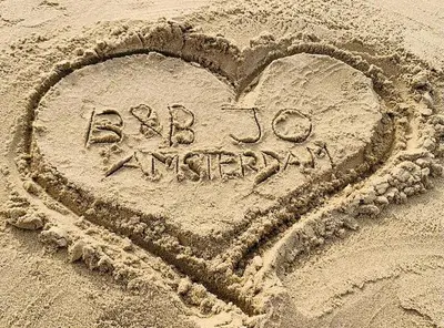 a heart drawn in the sand on the beach at Bed & Breakfast Jo Amsterdam in Amsterdam
