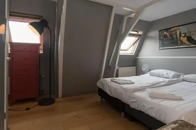 a bedroom with a bed and a red dresser at Westerpark Suites in Amsterdam