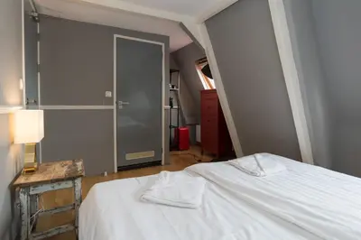 a bedroom with a bed with a white bedspread at Westerpark Suites in Amsterdam