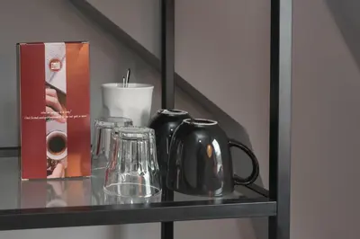 a glass shelf with a tea kettle and glasses on it at Westerpark Suites in Amsterdam