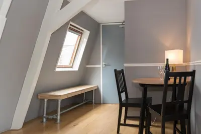 a dining room with a table and chairs and a window at Westerpark Suites in Amsterdam