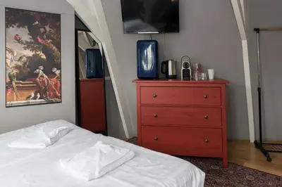 a bedroom with a bed and a dresser with a tv at Westerpark Suites in Amsterdam