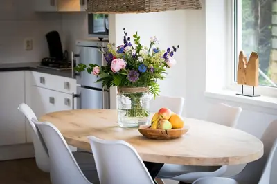 a table with a vase of flowers and a bowl of fruit at De Gouden Spar in Noordwijk